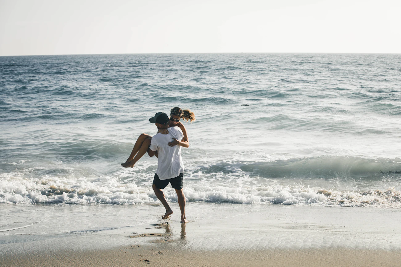 Kwame carrying Ana through the waves
