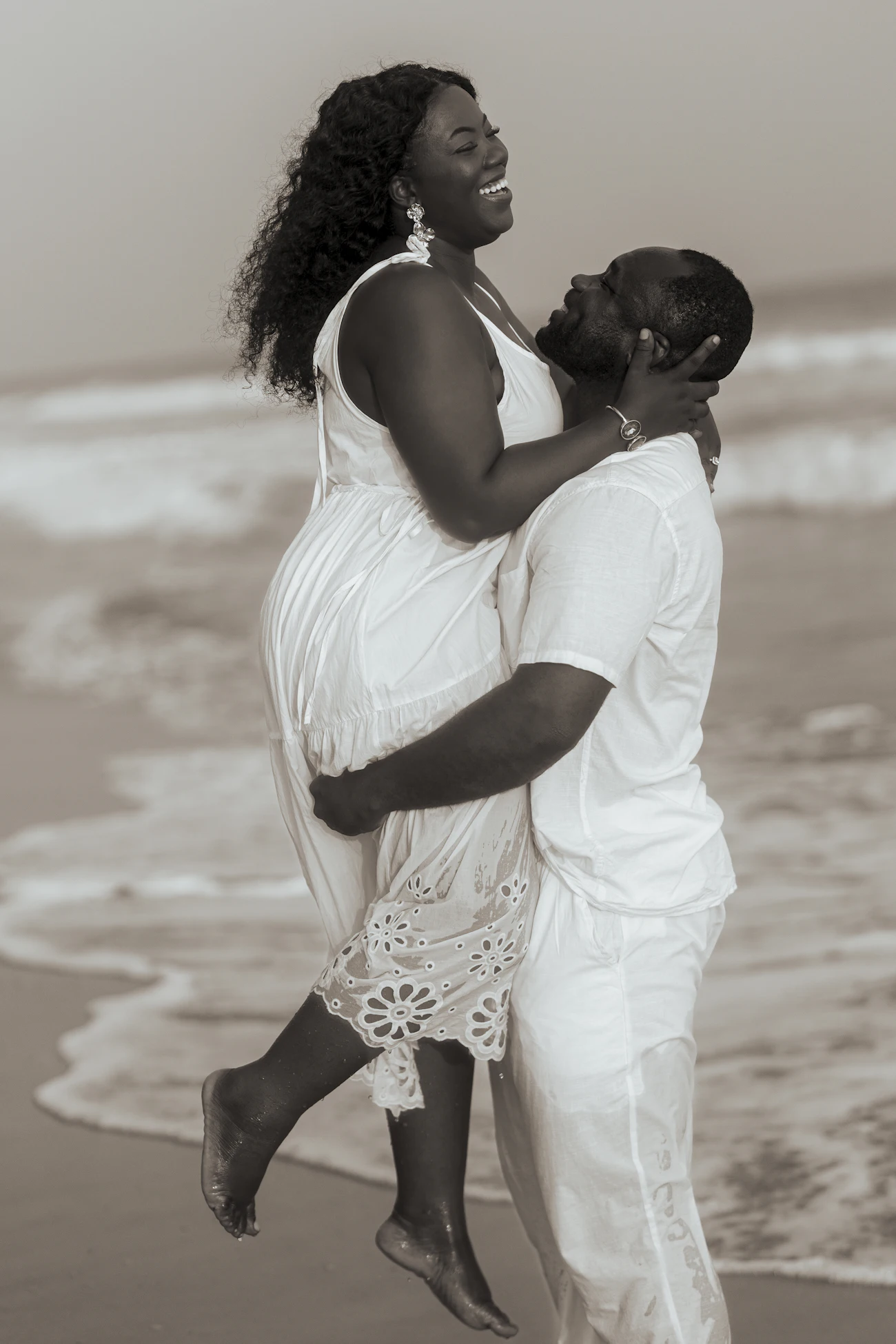 Ana jumping into Kwame's arms on the beach, both laughing
